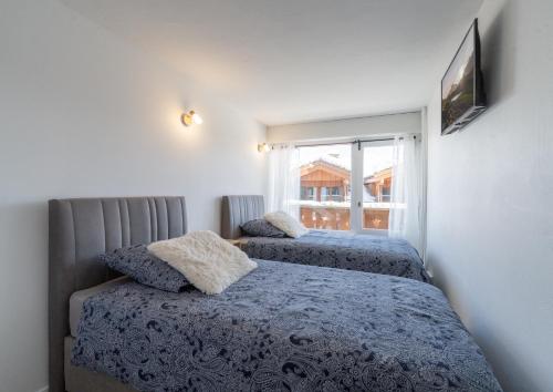 1 dormitorio con 2 camas y ventana en Cosy Home Center 1850-Croisette en Courchevel