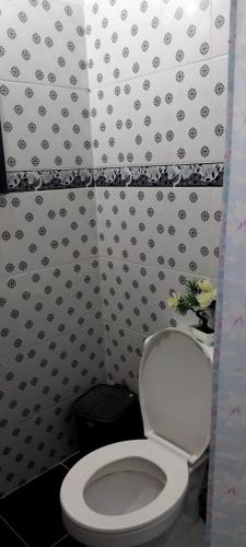 a bathroom with a toilet and a black and white wall at acogedora casa Rochi in Guaduas