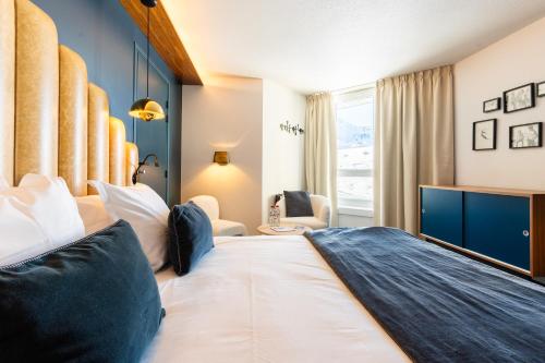 Fahrenheit Seven Val Thorens في فال تورن: غرفة فندقية بسرير كبير ونافذة