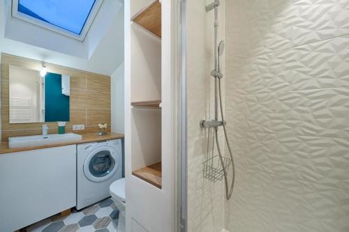a bathroom with a shower and a washing machine at Studio Olivia in Montgeron