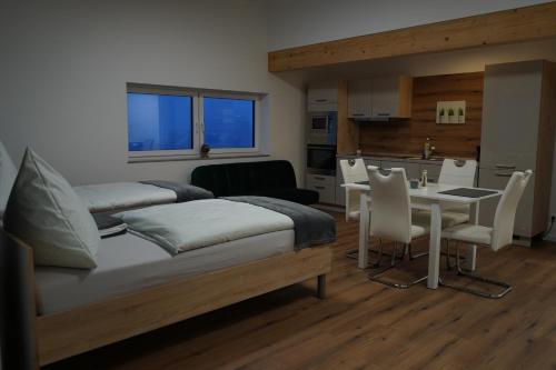 a bedroom with two beds and a table and a kitchen at Bruchersee 4 oberbergisches Land in Marienheide