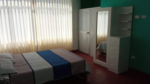 1 dormitorio con 1 cama y vestidor en Suit Quilla en Quillabamba