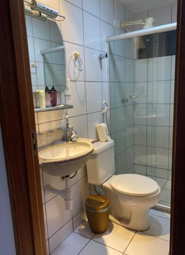 La salle de bains est pourvue de toilettes, d'un lavabo et d'une douche. dans l'établissement Apt temporada em Ponta Verde, à Maceió