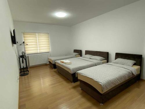 a room with three beds and a window at Apartmani Bella in Krževići