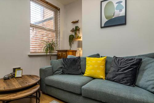 een woonkamer met een blauwe bank en een houten tafel bij 3 BR Terraced House in Beeston with Easy City Centre Access in Nottingham