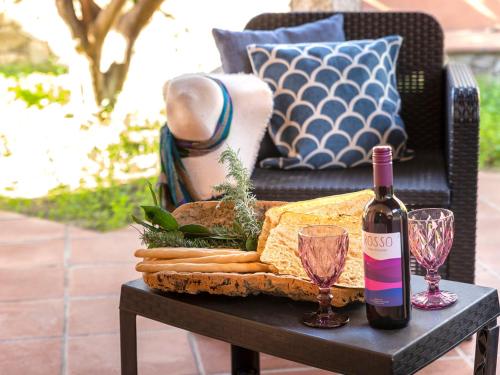 un tavolo con una bottiglia di vino e due bicchieri di Apartment F4-F1 by Interhome a Marinella