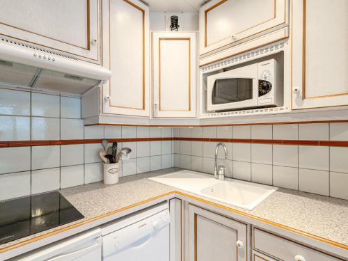une cuisine avec un évier et un micro-ondes dans l'établissement Apartment Le Prariond - Val Claret-4 by Interhome, à Tignes