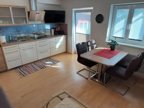 eine Küche mit einem Tisch und Stühlen im Zimmer in der Unterkunft Apartment Rupertus-2 by Interhome in Maishofen