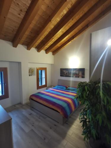 1 dormitorio con 1 cama con un colorido edredón a rayas en Luxury Home, en Codognè