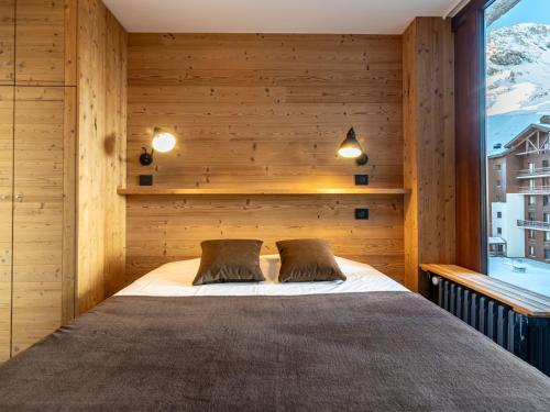 um quarto com uma cama numa parede de madeira em Apartment Le Pramecou - Val Claret-8 by Interhome em Tignes