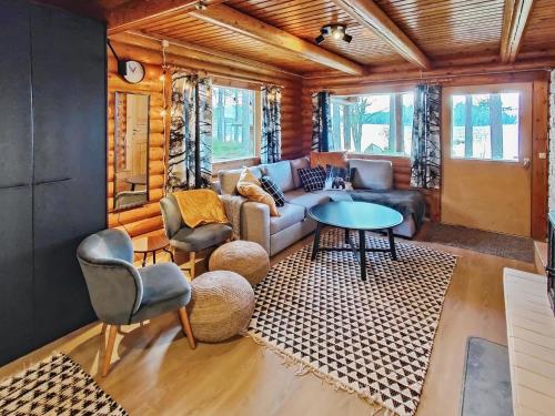 a living room with a couch and a table at Holiday Home Kuusela by Interhome in Soini