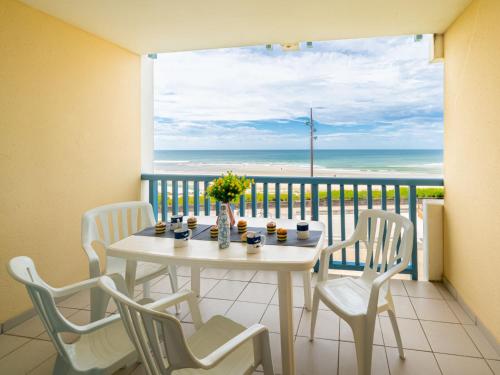 una mesa y sillas en un balcón con vistas al océano en Apartment Les Hauts de la Corniche by Interhome, en Mimizan-Plage