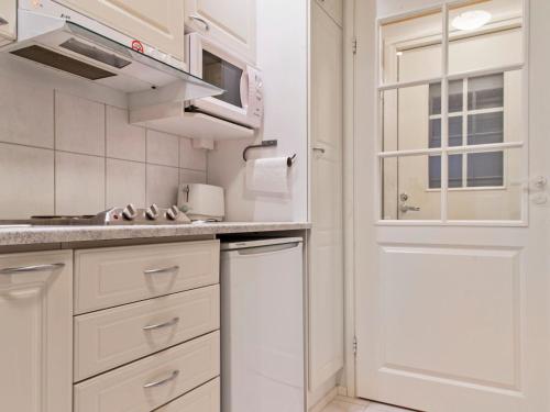 uma cozinha branca com armários brancos e uma janela em Holiday Home Yllästar 1 as 208 - la-la by Interhome em Äkäslompolo