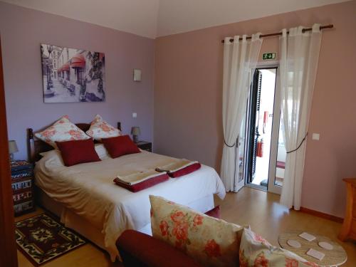 ポンタ・ド・パールゴにあるJasmine Guest Suiteのベッドルーム1室(ベッド1台、ソファ、窓付)