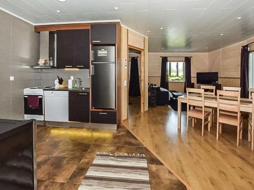 een keuken en eetkamer met een tafel en een koelkast bij Holiday Home Lepovalkeinen by Interhome in Pylkönmäki