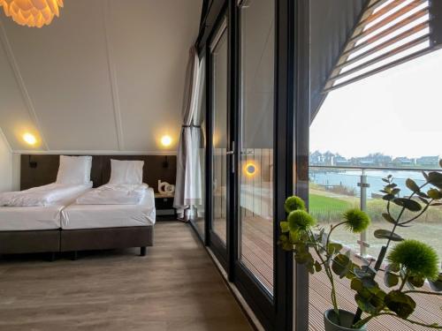 a hotel room with a bed and a balcony at Holiday Home Oesterdam Resort by Interhome in Tholen