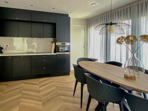 a kitchen and dining room with a table and chairs at Holiday Home Oesterdam Resort by Interhome in Tholen