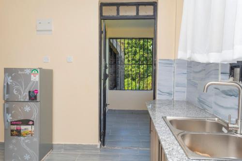 eine Küche mit einer Spüle und einem Kühlschrank in der Unterkunft Arabella Apartments in Bungoma