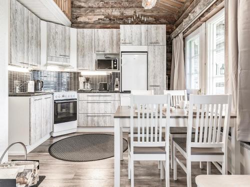 ルカにあるHoliday Home Revonaapa b14 by Interhomeの白いキャビネット、テーブルと椅子付きのキッチンが備わります。