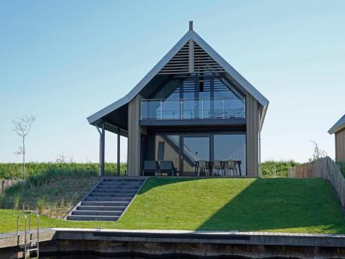 una casa de cristal con techo en una colina con césped en Holiday Home Oesterdam Resort by Interhome en Tholen