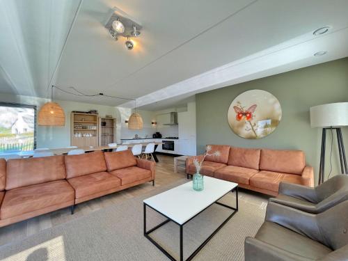 un soggiorno con divano e tavolo di Holiday Home Oesterdam Resort-1 a Tholen