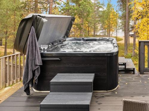a hot tub on a deck with a towel at Holiday Home Peurakumpu by Interhome in Ivalo