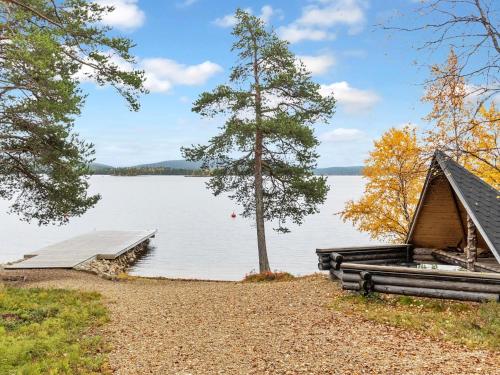 a cabin on the shore of a lake with a dock at Holiday Home Peurakumpu by Interhome in Ivalo