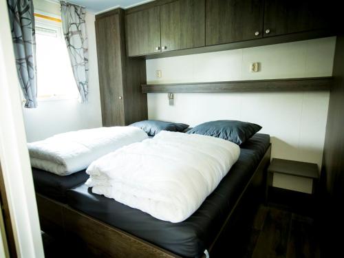 duas camas sentadas num banco num quarto em Holiday Home Duinhoeve-1 by Interhome em Udenhout