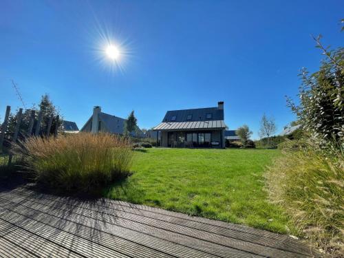 een huis op een groen veld met de zon in de lucht bij Holiday Home Oesterdam Resort-1 by Interhome in Tholen