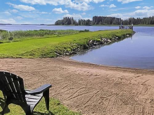 un banc assis à côté d'une masse d'eau dans l'établissement Holiday Home Ruokovirran mökki by Interhome, à Siilinjärvi