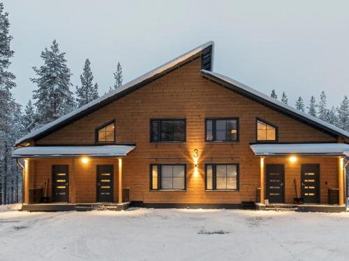 a large wooden house in the snow with trees at Holiday Home Hankielämä b by Interhome in Sirkka