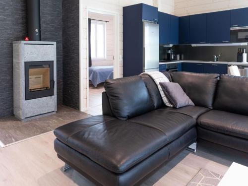 a living room with a leather couch and a fireplace at Holiday Home Saana 3 by Interhome in Kilpisjärvi
