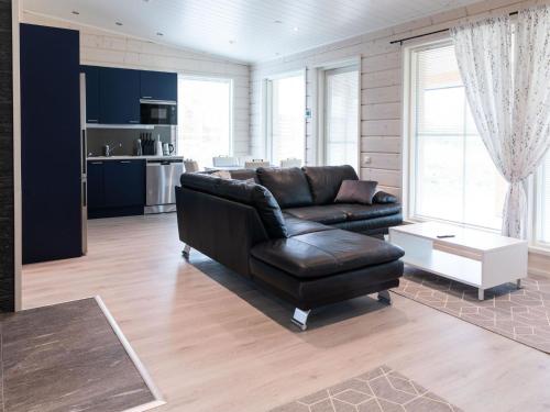 a living room with a leather couch and a kitchen at Holiday Home Saana 3 by Interhome in Kilpisjärvi