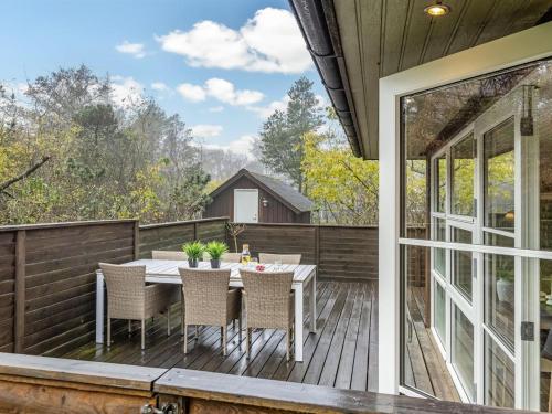 a patio with a table and chairs on a deck at Holiday Home Calle - 1km from the sea in Western Jutland by Interhome in Vejers Strand