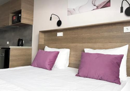 een slaapkamer met een bed met paarse kussens bij VIP apart 607 in Tbilisi City