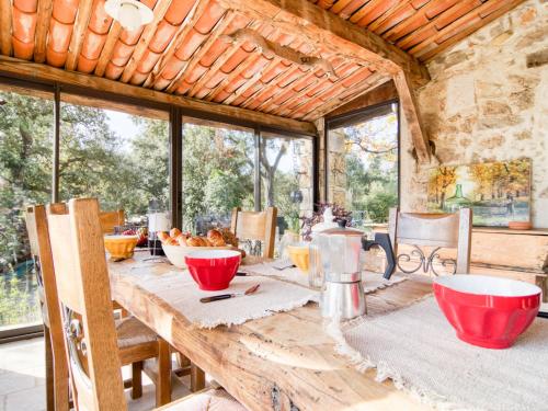 a dining room with a wooden table with red bowls at Holiday Home Chez Canard by Interhome in Ampus