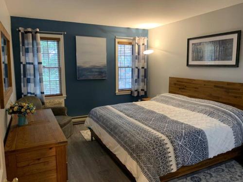 a bedroom with a large bed and two windows at Jiminy Peak Mountainside Getaway in the Berkshires in Hancock