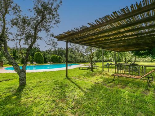 a picnic table and benches under a pavilion near a pool at Apartment Malva by Interhome in Sorano