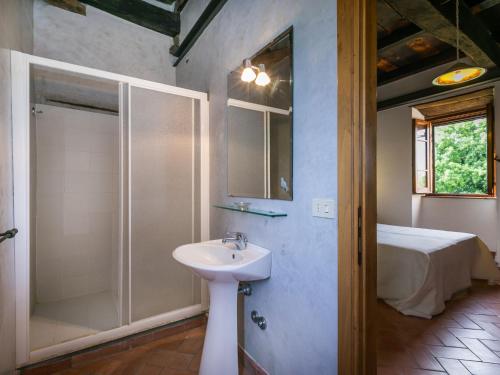 a bathroom with a sink and a shower and a bed at Apartment Malva by Interhome in Sorano