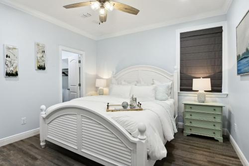 1 dormitorio blanco con 1 cama blanca y ventilador de techo en Cottage Bundle, en Bay Saint Louis