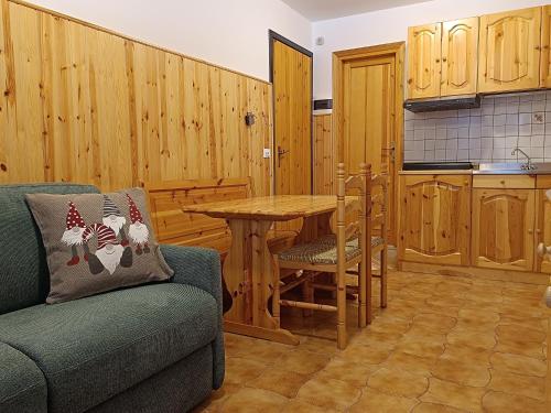 uma sala de estar com um sofá e uma mesa numa cozinha em Collalto Guest House em Piancavallo