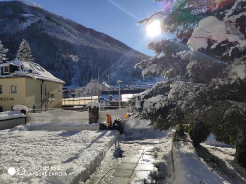 a snow covered yard with a house and a mountain at Hotel Lindenhof in Bad Gastein