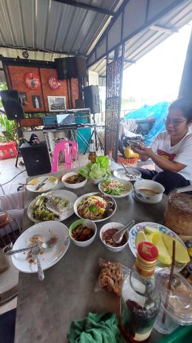 une table avec de nombreuses assiettes de nourriture dans l'établissement บ้านเพลินภู, à Khao Kho