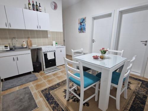 - une cuisine avec une table et des chaises blanches dans la chambre dans l'établissement Apartman Mihajlovic Brus, à Brus