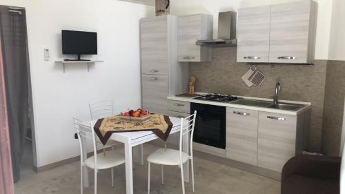 a small kitchen with a table and chairs and a sink at CASA VACANZE ZOE - Terra in Serrano
