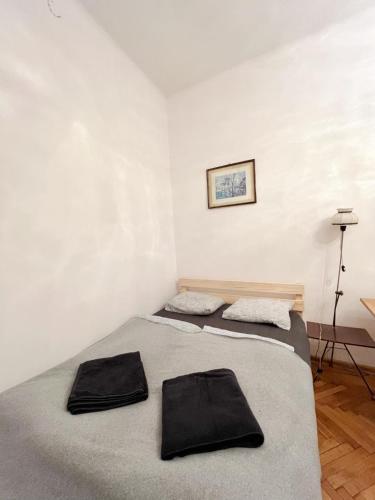 2 łóżka w pokoju z białymi ścianami w obiekcie Cozy studio in Cracow w Krakowie