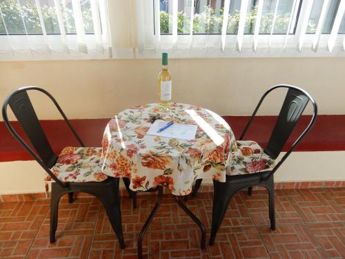 Jasmine Guest Suite في بونتا دو بارغو: طاولة وكرسيين عليها زجاجة من النبيذ