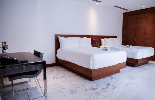 een slaapkamer met 2 bedden, een bureau en een piano bij Hotel San Felipe in Panama-Stad