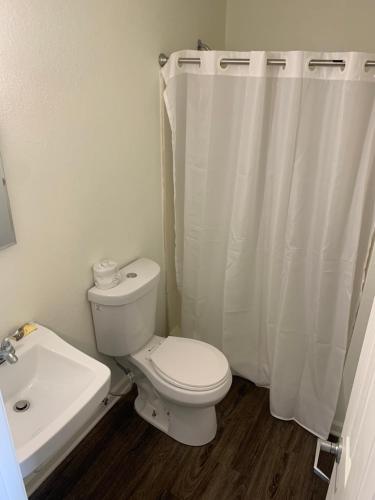 Baño blanco con aseo y lavamanos en My Town Extended Stay, en Nashville