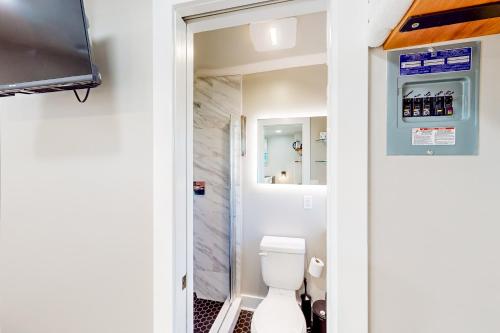 a bathroom with a toilet and a television in it at Beach 5 Villas #B4 in Fernandina Beach